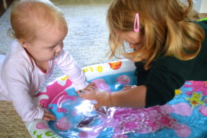 toddler and baby splashing on the Teletubbies Inflatable Aqua Mat