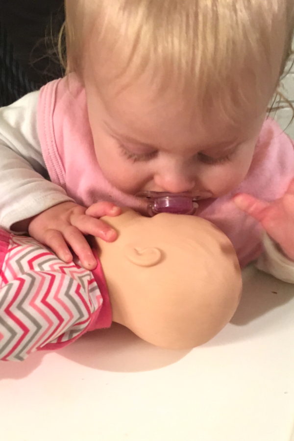 baby girl kissing baby doll