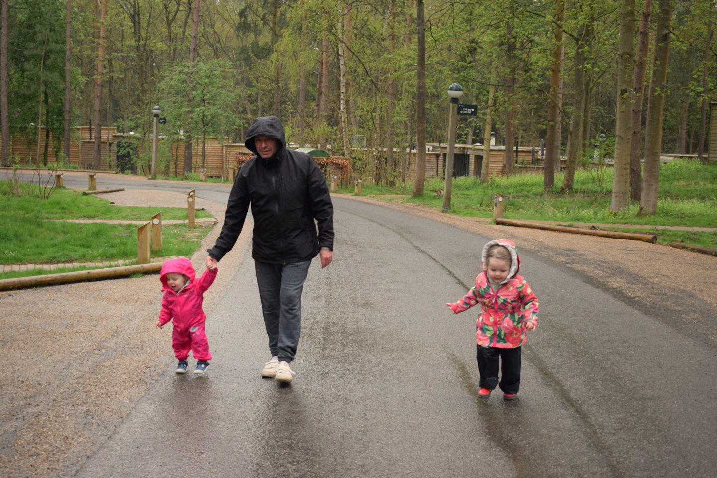 Dad and two daughters on rainy walk at Center Parcs Elveden Forest