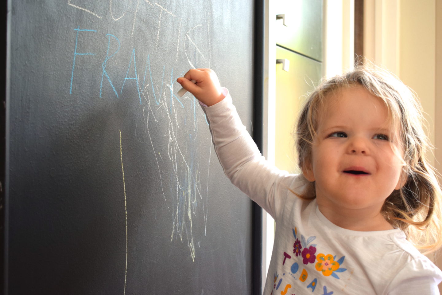 Toddler writing on blackboard wall at Center Parcs Elveden Forest