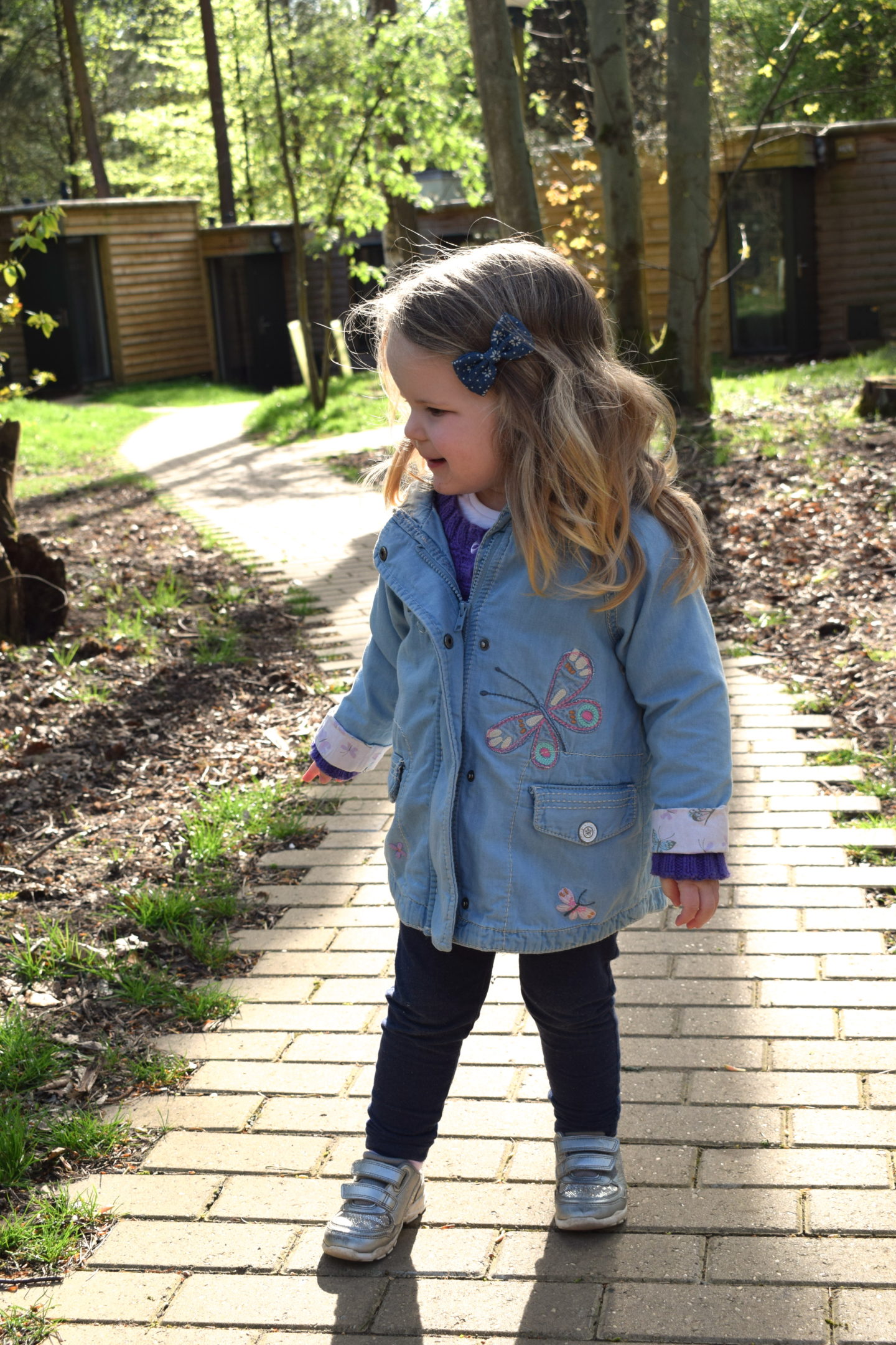 two year old girl standing on a path at Center Parcs Elveden Forest