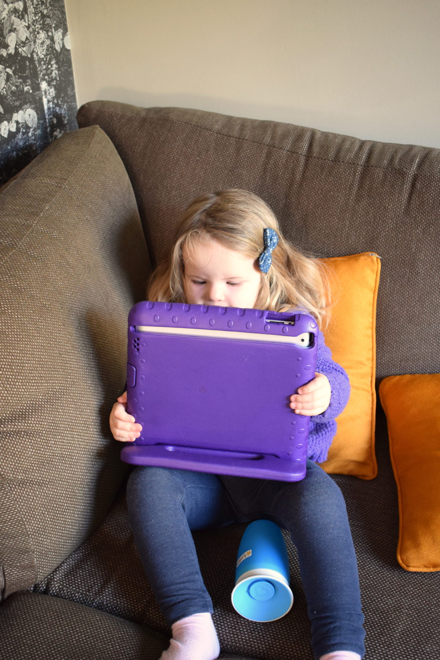 two year old girl watching ipad on the sofa at Center Parcs Elveden Forest