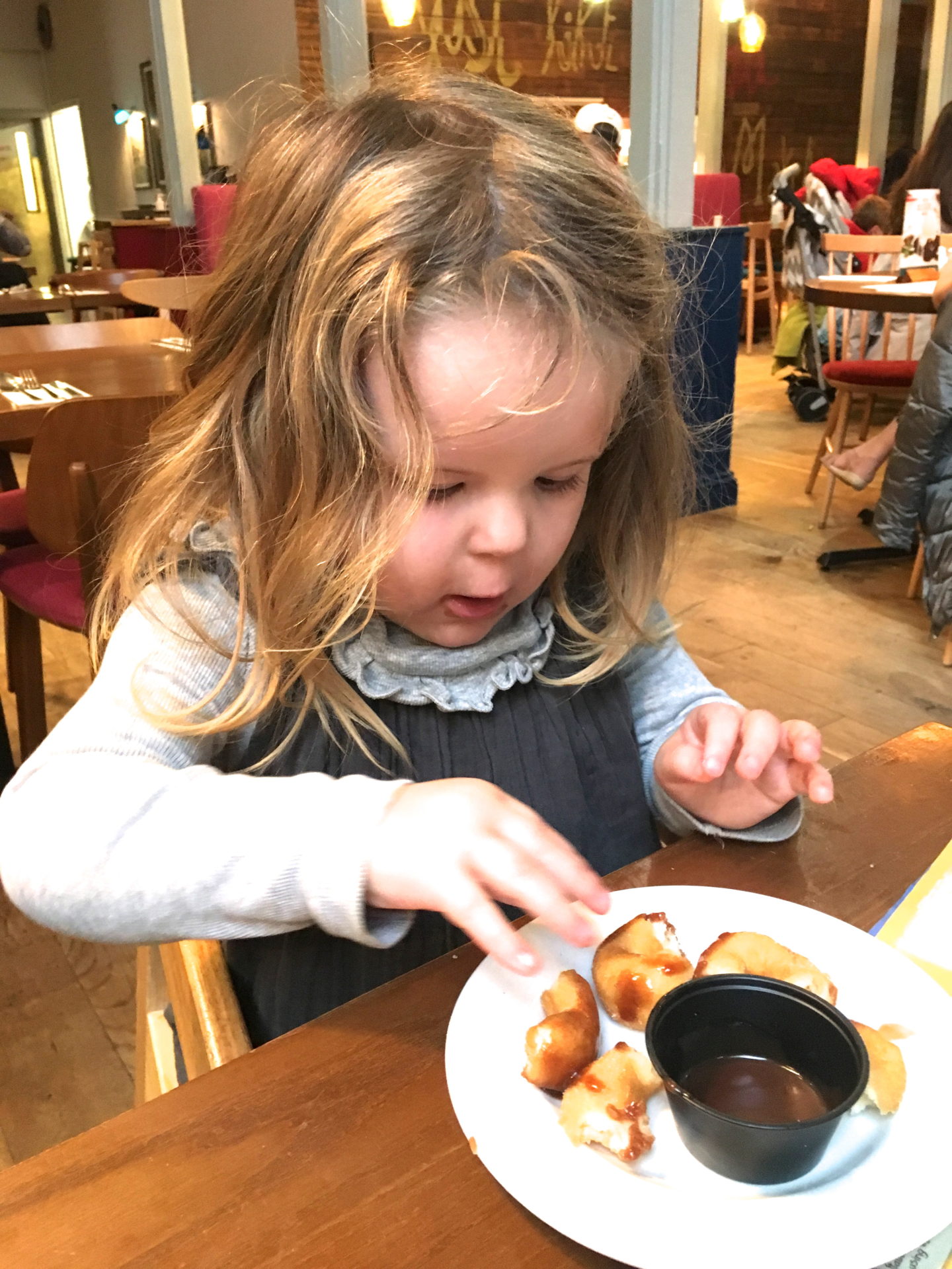 two year old girl eating pudding atBella Italia Center Parcs Elveden Forest