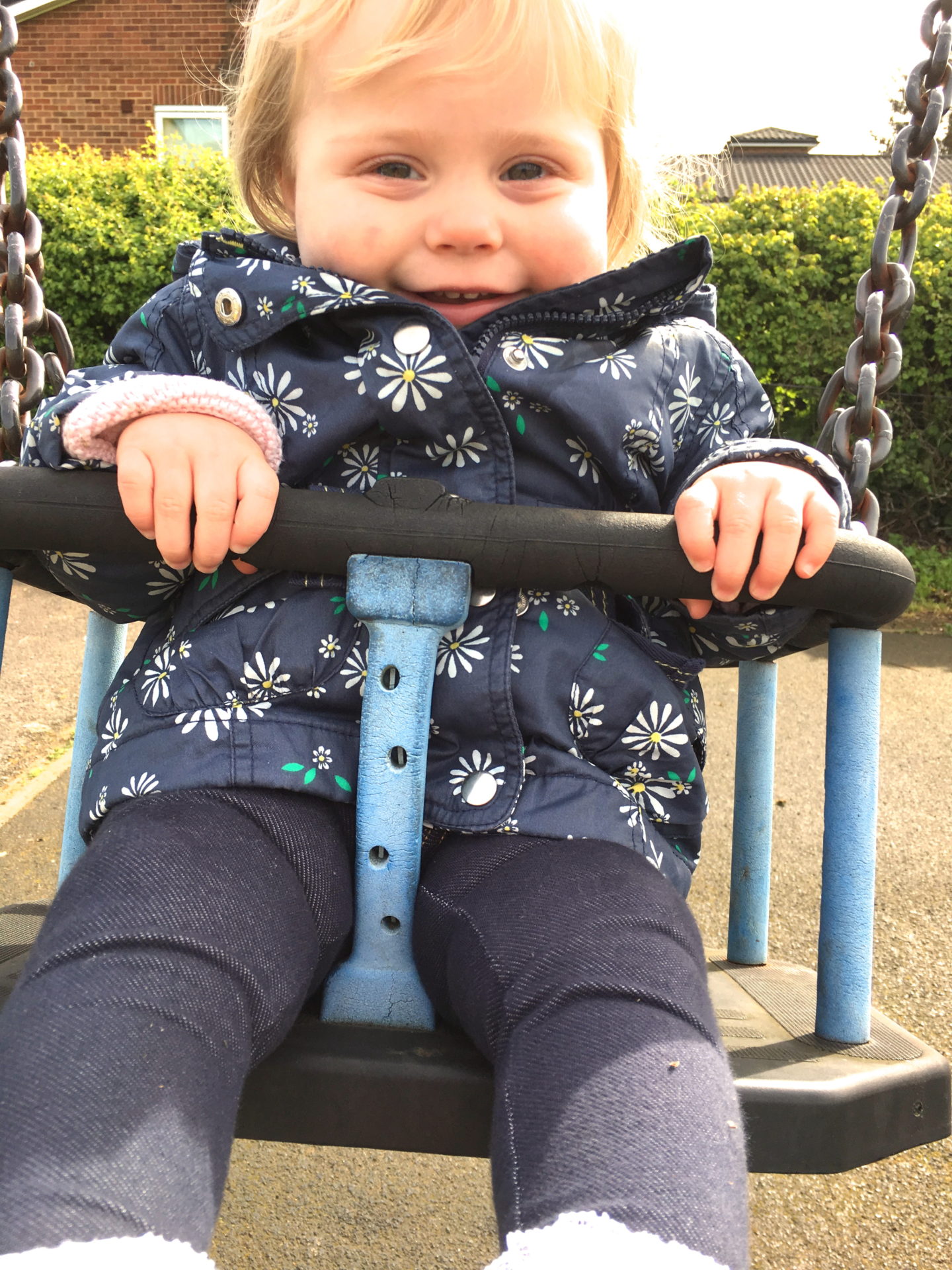 14 months old girl sitting in a swing