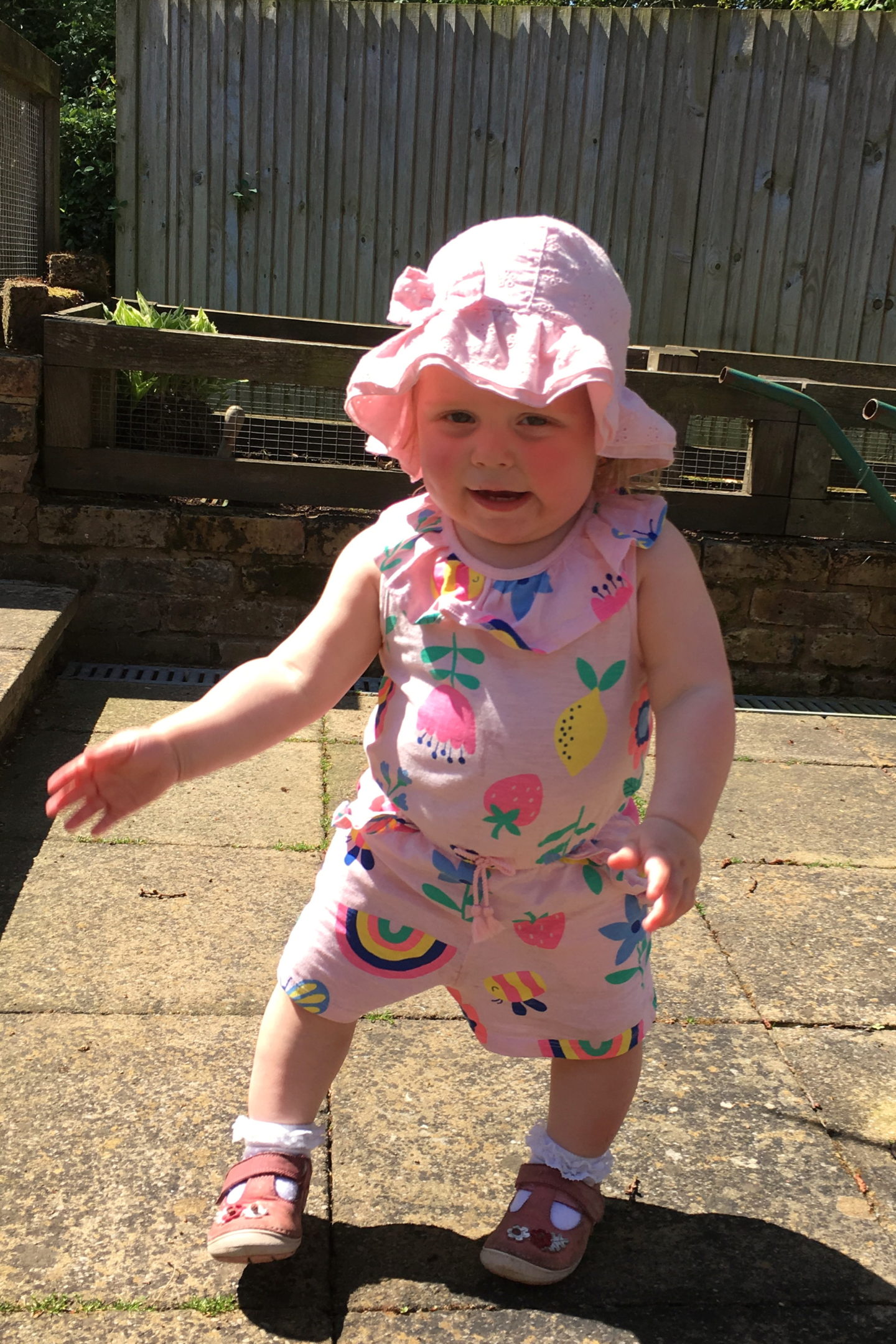 14 months old girl, dancing in the garden in sunshine