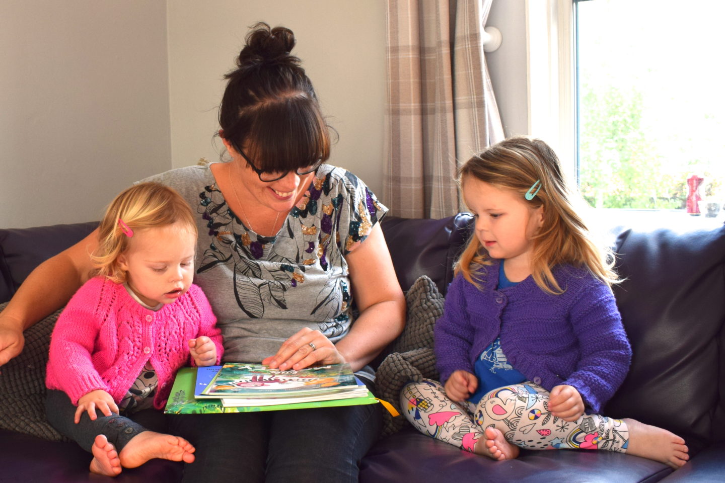 mother making time to read with preschool girls