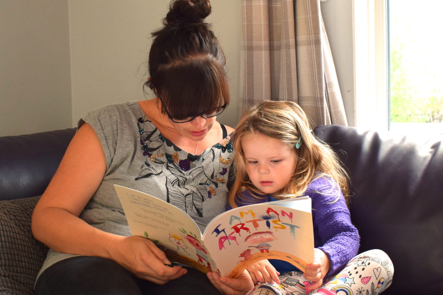mother making time to read with three year old