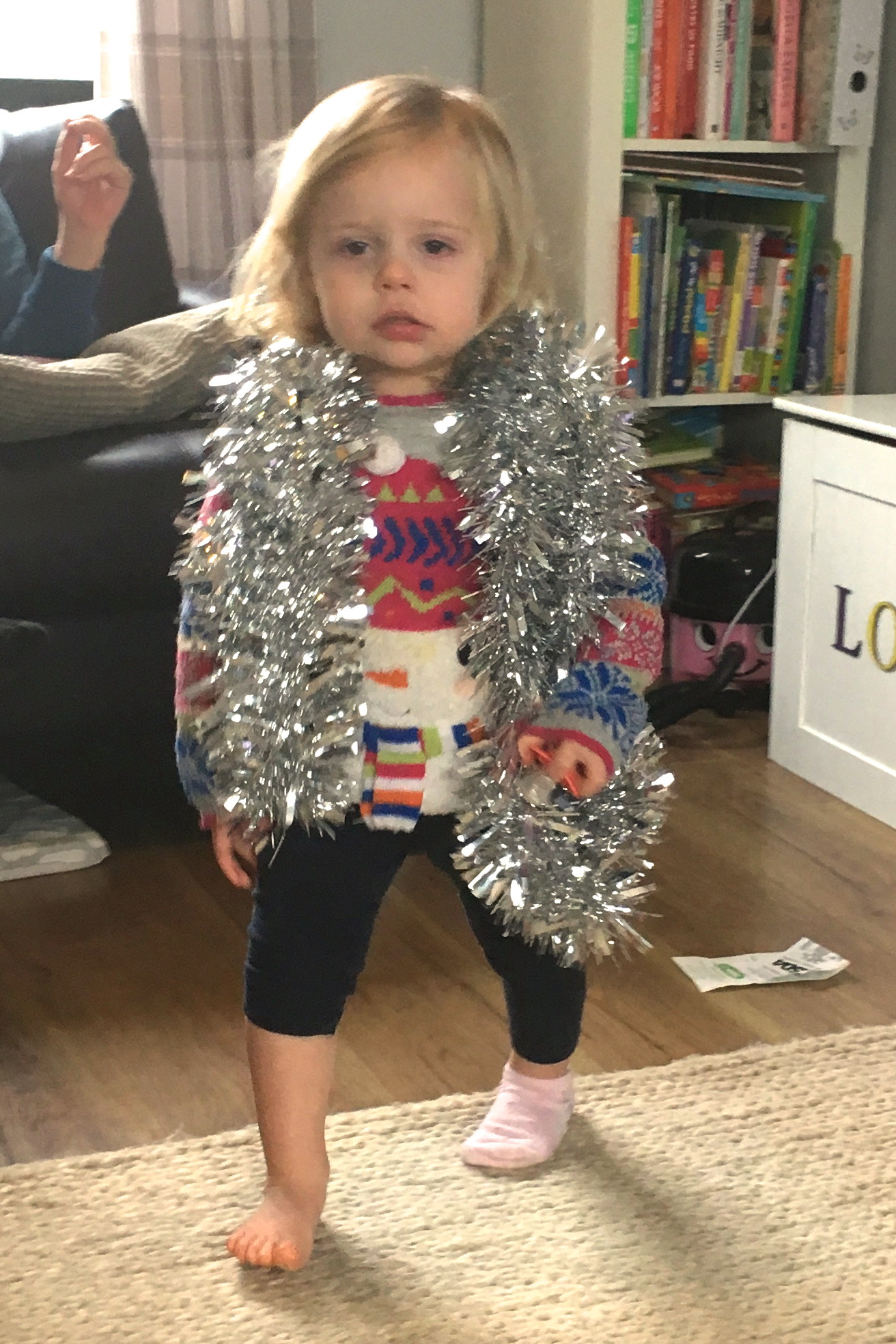 22 months old girl with tinsel around her shoulders