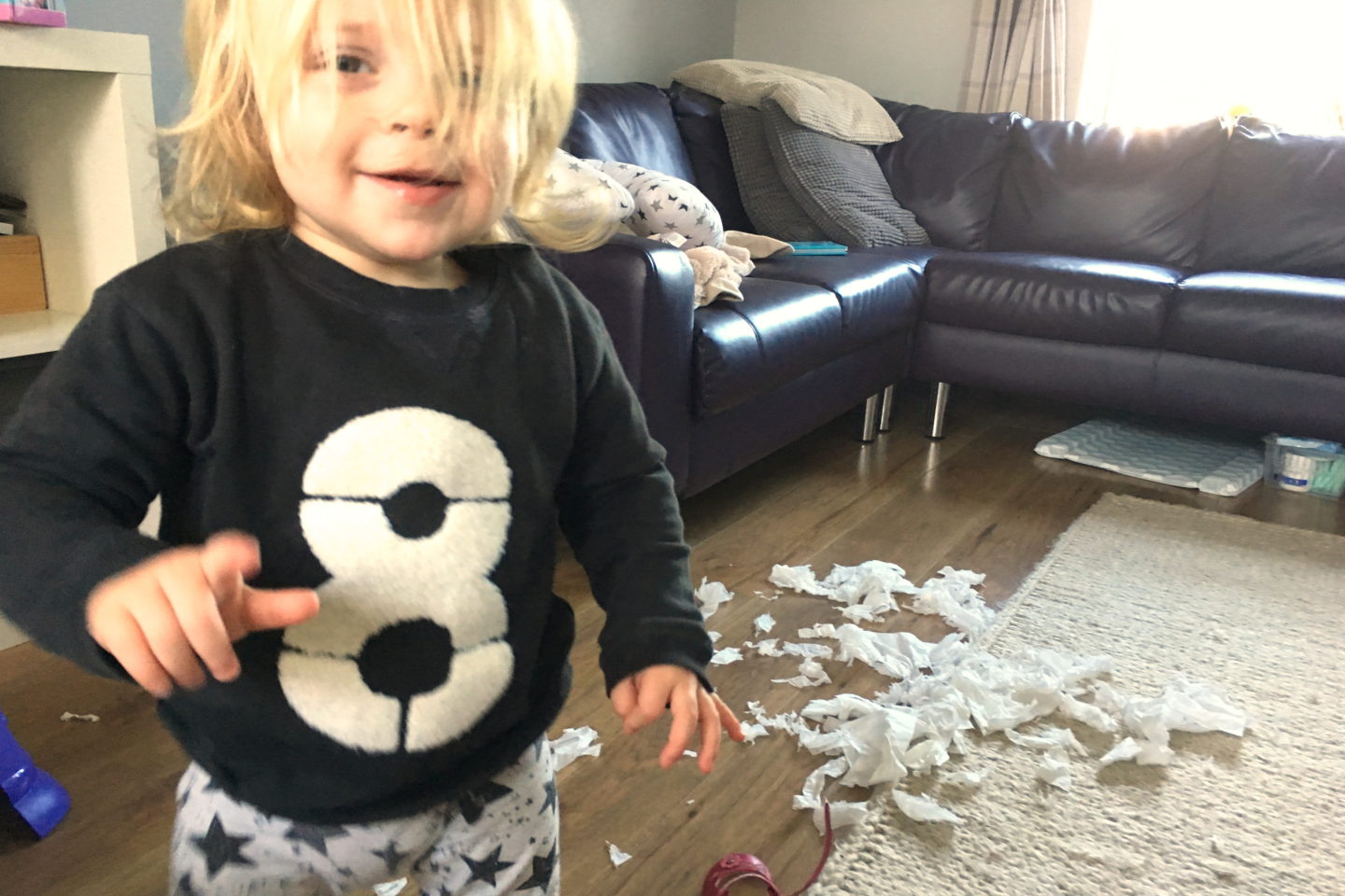 22 months old girl with box of tissues tipped up on the floor