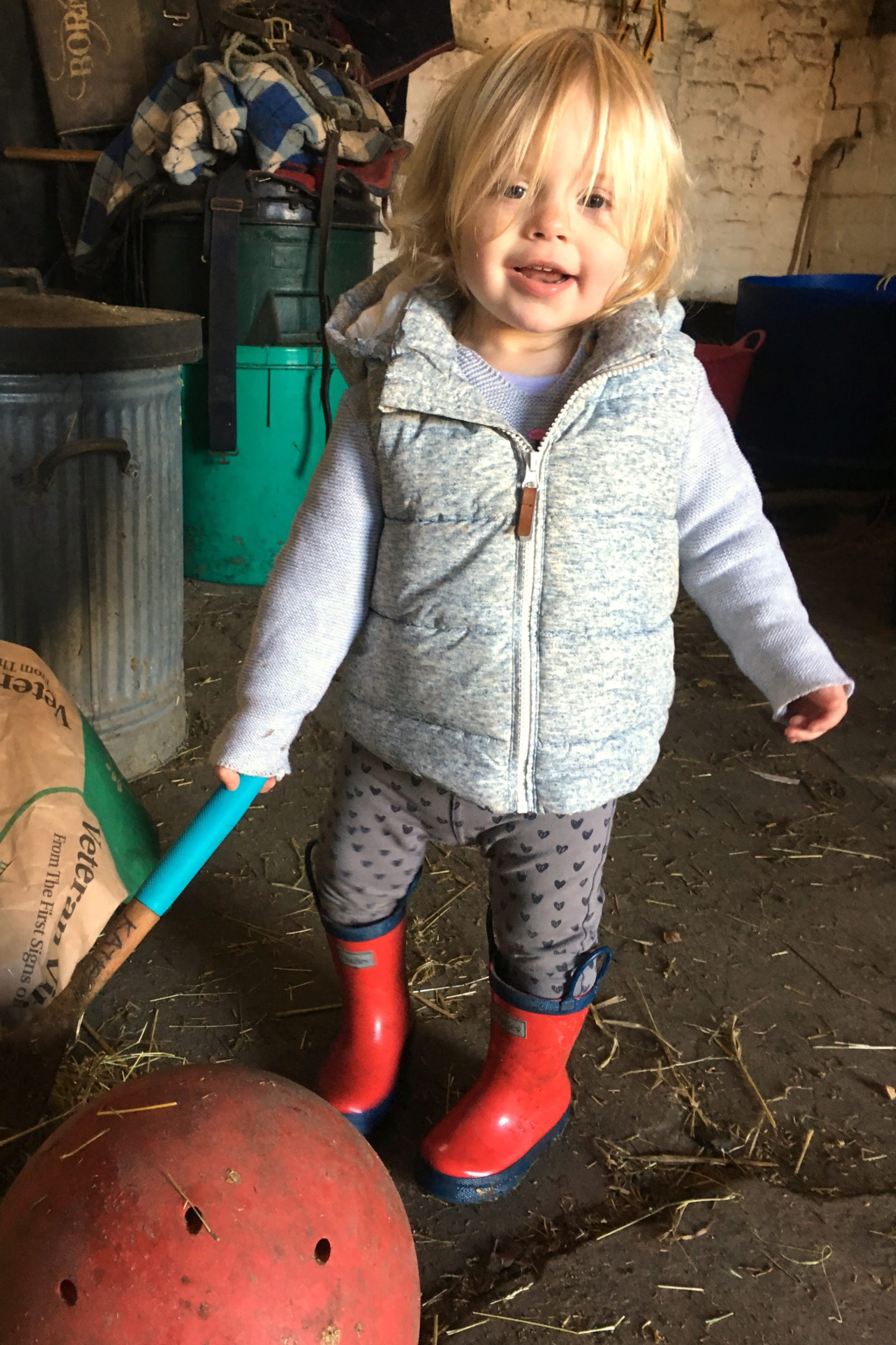 22 months old girl, helping make feeds at the stables