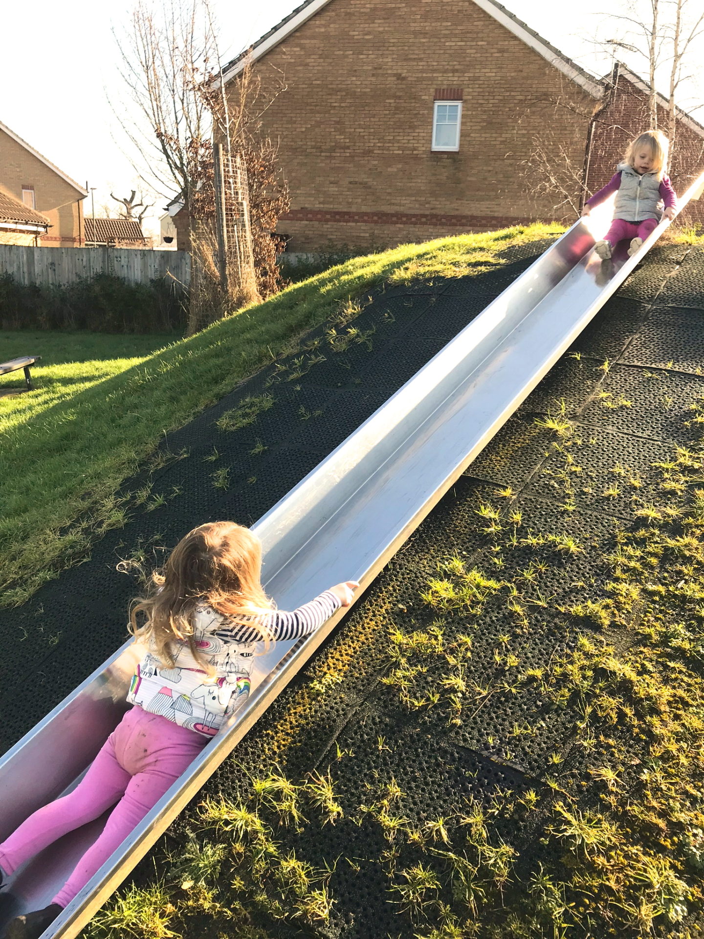 two sisters playing on a slide
