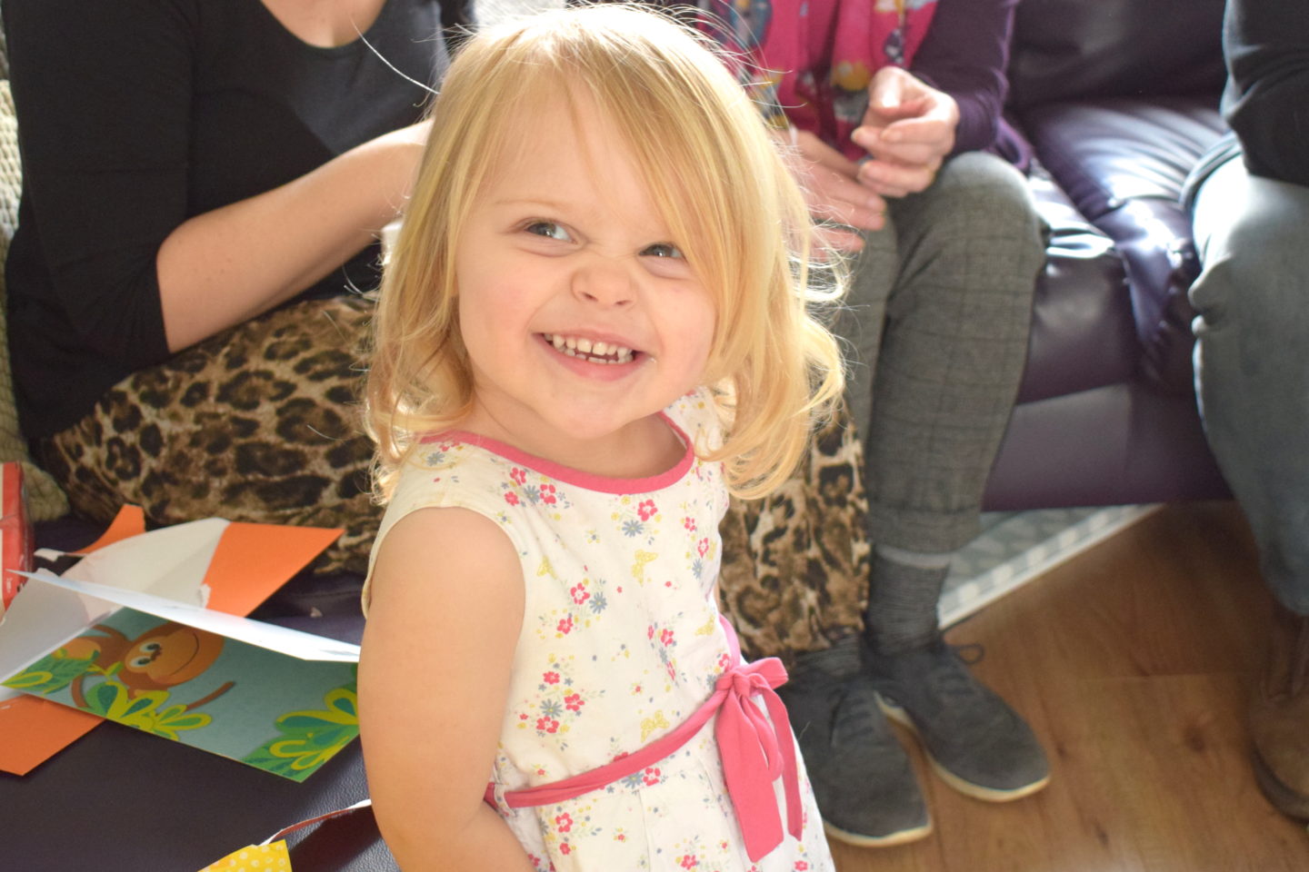 Two year old in a party dress, smiling at the camera