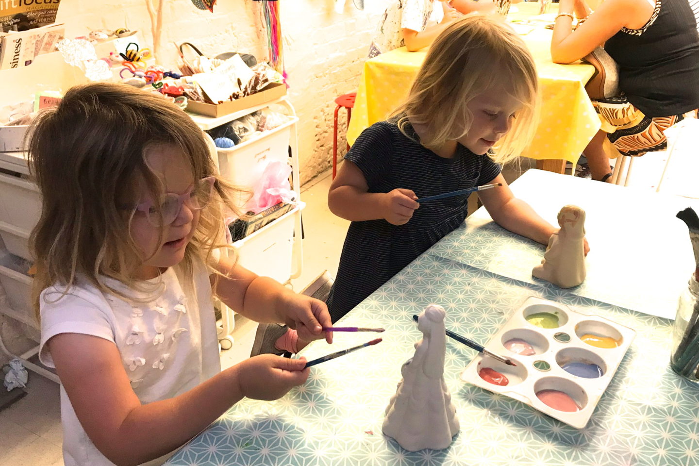 Two sisters painting pottery
